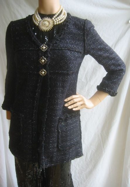 CHANEL '07 Elegant Tweed Jacket with Gripoix Cross Button <br />
<br />
This gorgeous coat is made of Chanel's signature fantasy tweed that's a soft cotton blend. The fabric is in shades of navy blue, black with flecks of silver. Designed with a