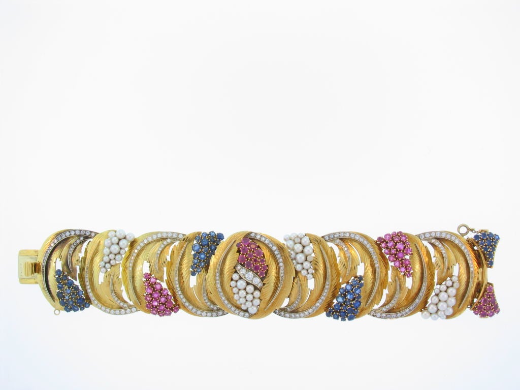 18K bracelet set with diamonds, rubies, sapphires and pearls.  There is an Omega watch which is concealed beneath the central section.