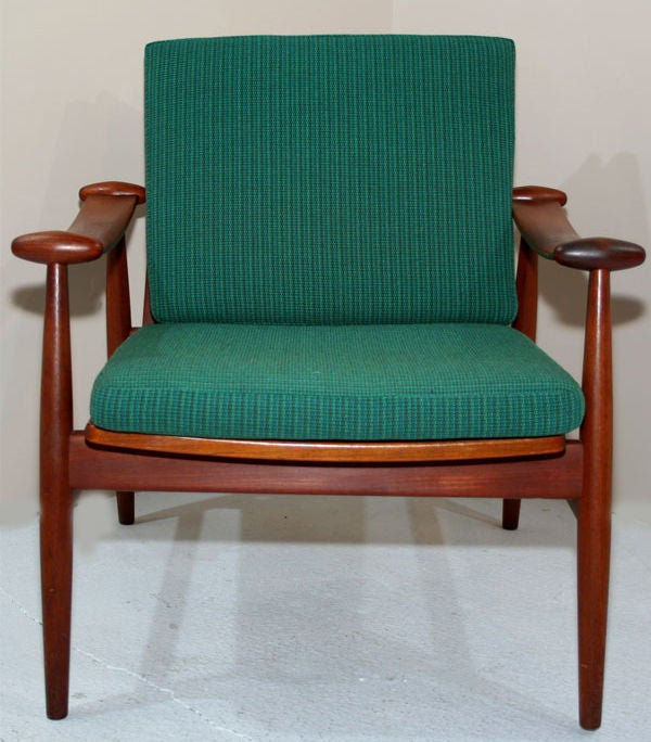 A pair of 'Spade' chairs in teak with sculpted sling arms, loose seat and back cushions. Model no. FD133. By Finn Juhl for France and Sons. Denmark, circa 1950.