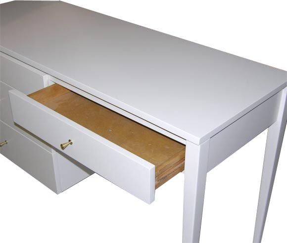 Paul McCobb planner group white satin lacquer desk newly restored with solid brass conical pulls.4 drawers with kneehole area make this elegant yet practical in function.<br />
This item is located at our 1stdibs booth in the New York Design Center