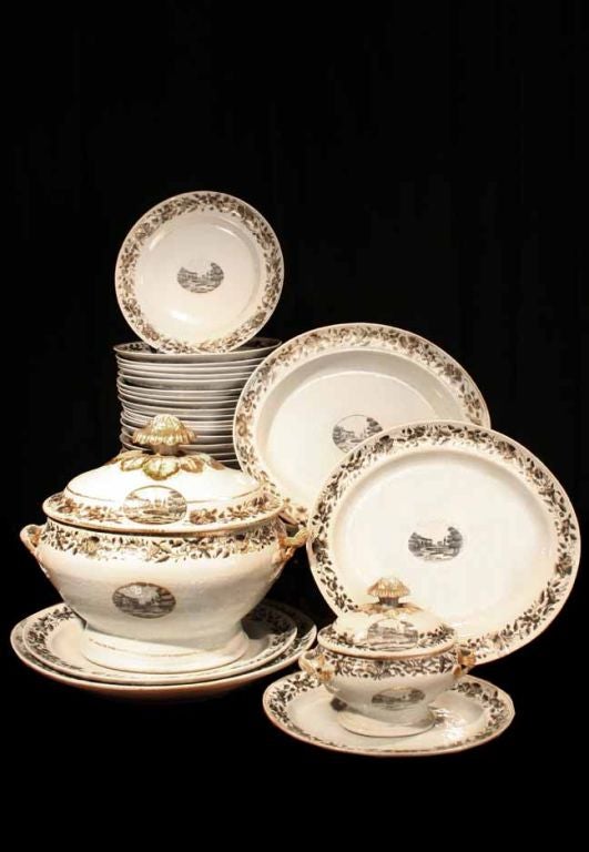 # G016 - Chinese Export porcelain dinner service decorated  in grisaille with gilt details. Each piece of this unique service is painted with an oval medallion showing a view of a country house. How appropriate for a service that was made in China