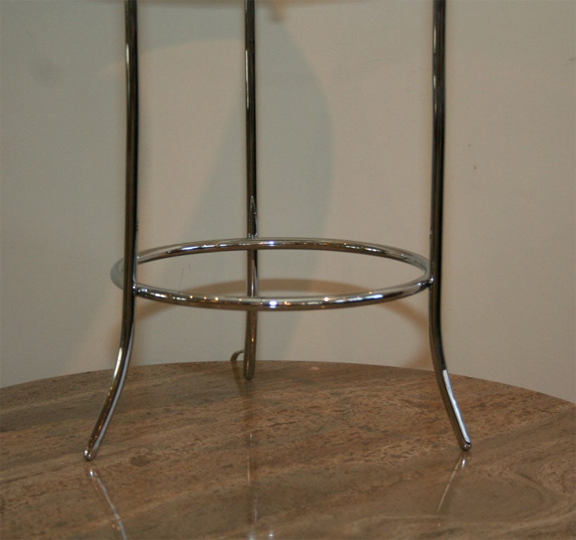 Table lamp with two circular tubes supported by three legs all nickel-plated.