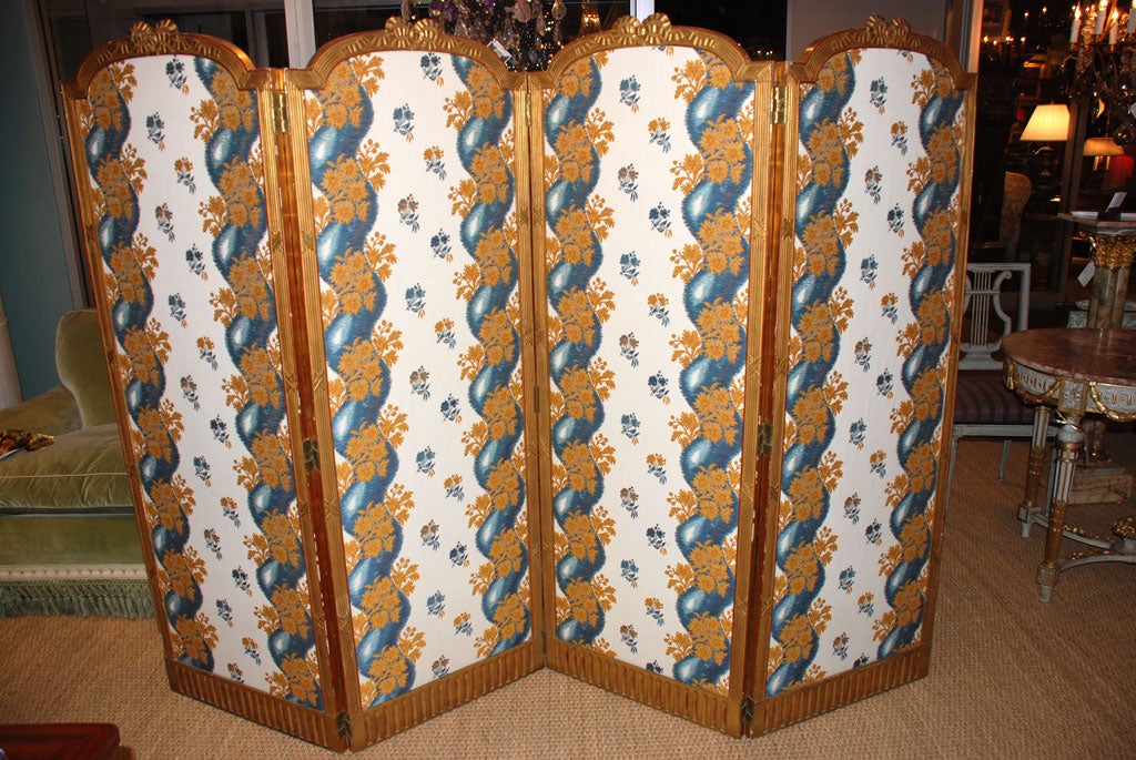 Paravent en bois doré de style Louis XVI, récemment recouvert de tissu Pierre Frey. Foldes à quatre panneaux avec de jolis détails de rubans et de nœuds.