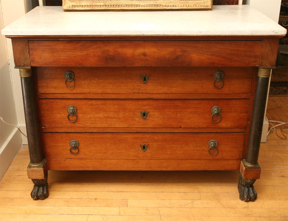 Empire 4 drawer chest has marble top. Columns with brass details at both sides end in lions paw feet. Original lions head<br />
brass drawer pulls.
