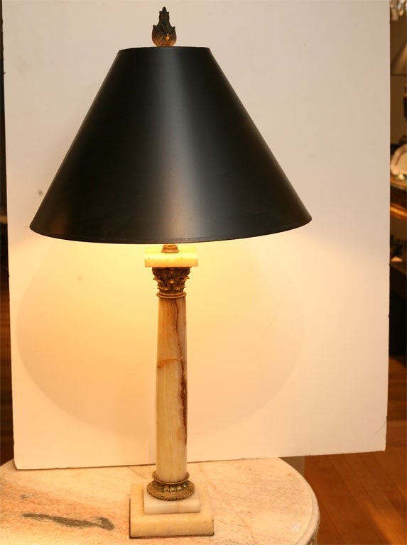 Antique marble column with gilded capitol and base with flame<br />
finial.