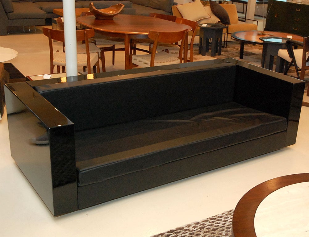Modern black lacquered sofa with upholstered leather seat.