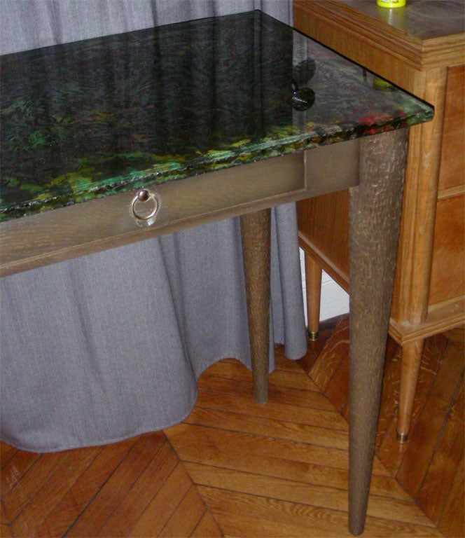 1960s table in oak worked with a chisel, with multicolored glass top, signed by Bragall.
Italy 