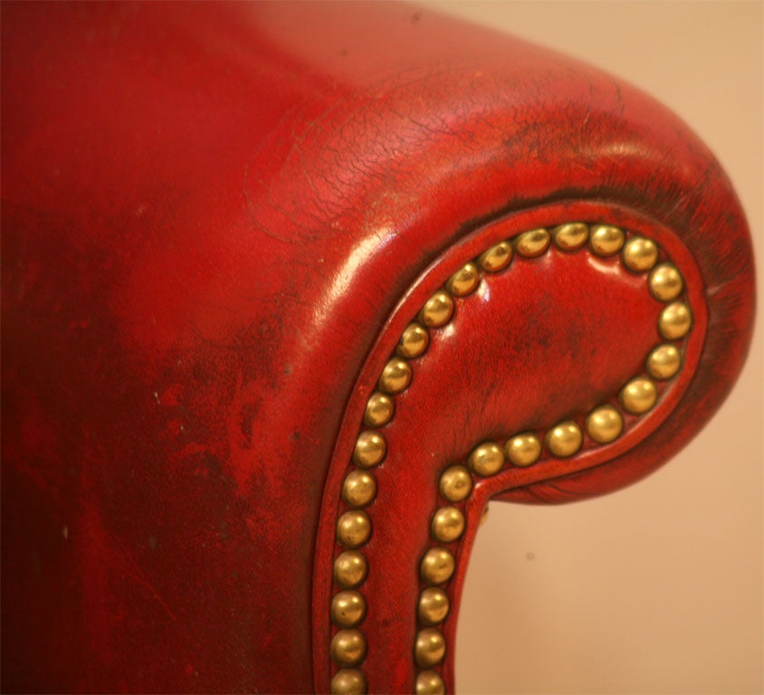 Red leather Wing Back chair, with brass studs, wood frame straight legs