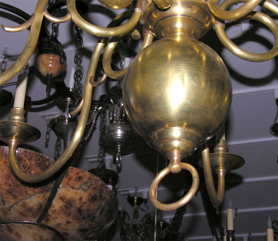 A 12 light Flemish Baroque style two-tiered polished brass chandelier. • Circa 1920 • 16” Drop, 41” Diameter