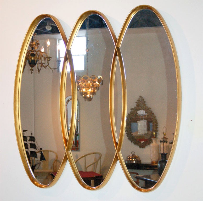Beautifully crafted carved wooden frame of three interlaced long ovals, all in a rich gilt finish.