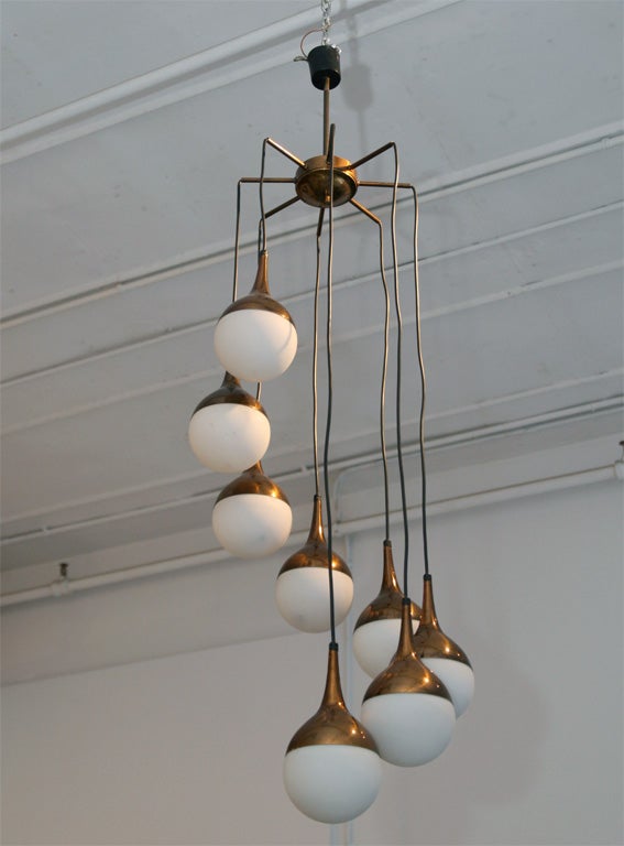 Eight white glass and copper bulbs dangle from the crown of this spectacular light. Featured in 