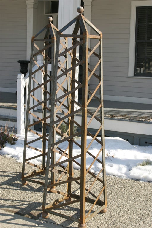 A very interesting pair of topiary forms in the shape of neoclassical obelsiks.They are a nice impressive size and because they are done in strap iron are easyly moved.