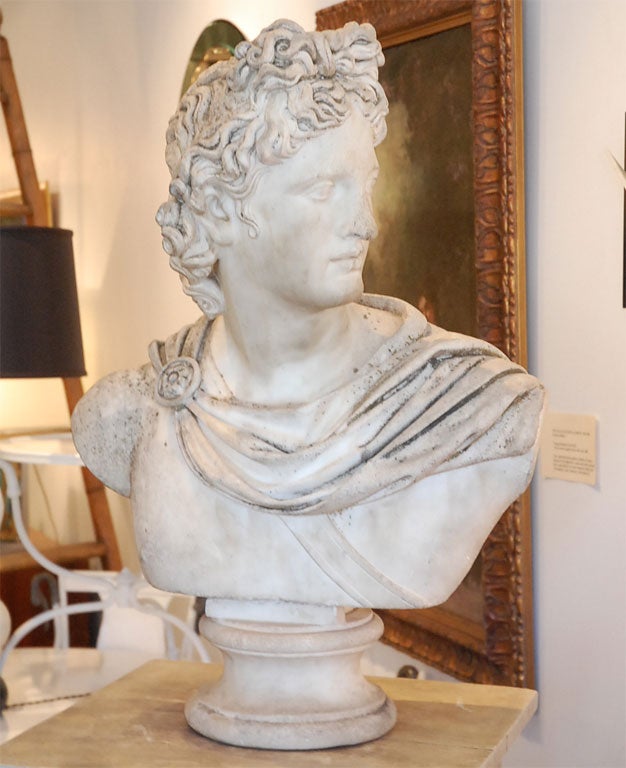 The noble youth with ringlet hair gazing sinister, with draperies over his shoulders caught by a circular fibula at the right, raised on a carved circular socle. Note: Carved after the original marble 300 AD 