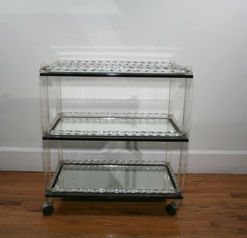 A original & good quality lucite & mirror three tiered bar cart from the Estate of Ron Grimaldi, former owner of Rose Cumming, Inc.<br />
Twisted glass baguettes around the edge of mirror shelves.