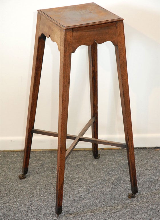 EARLY WALNUT TABLE ON CASTERS WITH EARLY CUT OUTS AROUND SKIRT OF TOP. ORIGINAL DRINK SLIDE OUTS BUILT IN TO TOP. WONDERFUL FORM AND PRESENCE. ORIGINAL CASTERS MADE OF BRASS. THIS IS A VERY RARE FORM IN A TABLE.