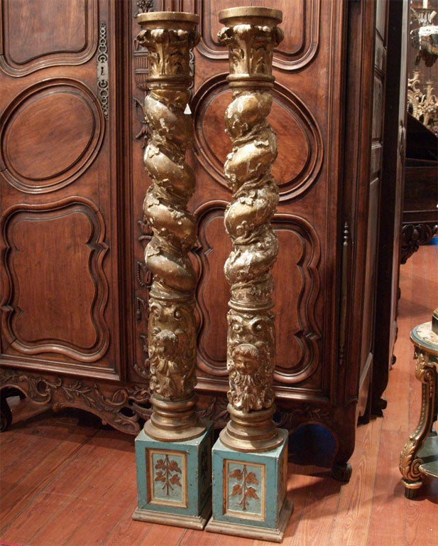 Pair of giltwood and paint salome columns with putti heads on painted plinths