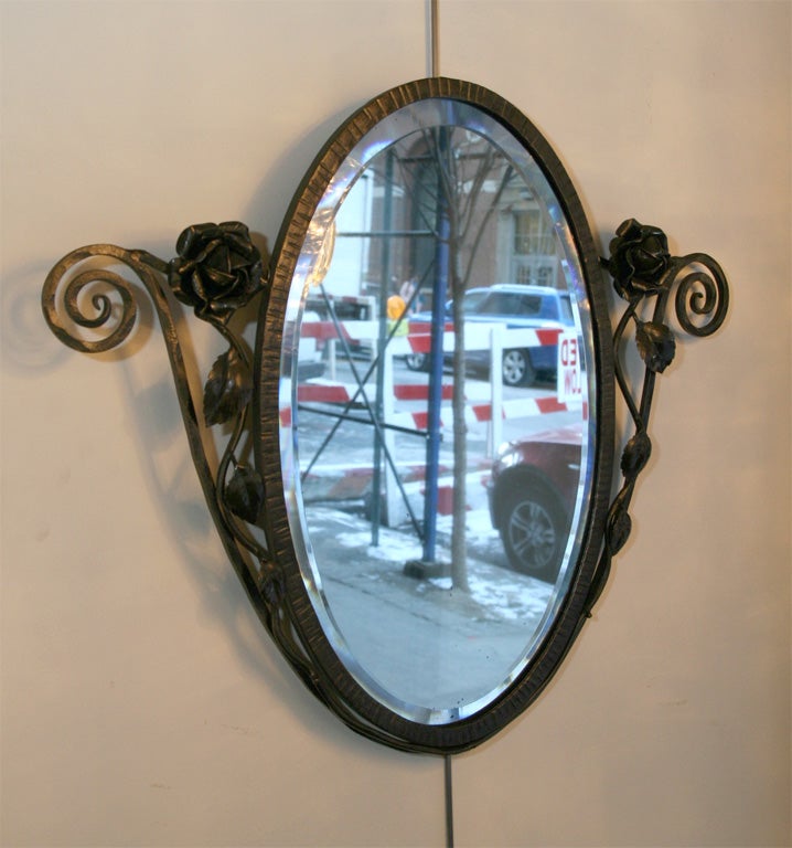 Hand beveled oval shaped mirror
with wrought iron frame with 
scroll and rose details.  Great
for a powder room, entry way, or
hallway.