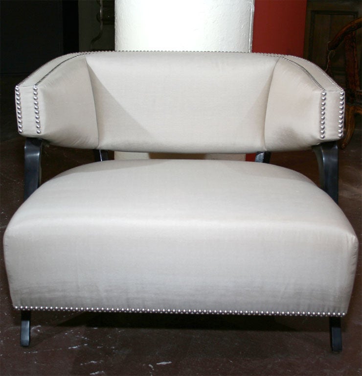 Sleek ebonized wood framed lounge chair with new pewter silk upholstery and nickel nailhead detail around perimeter.