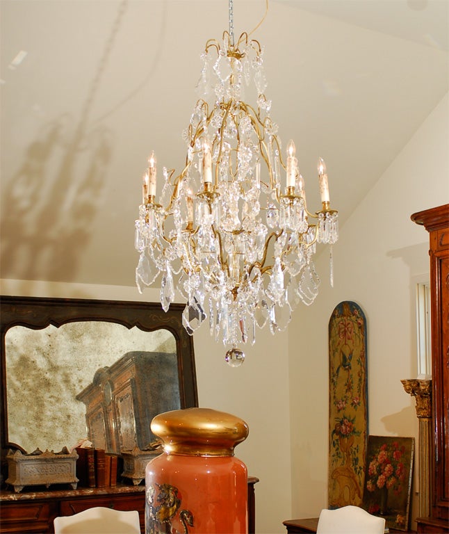 A French eight-light crystal chandelier from the late 19th century, with gilt brass frame and shaped crystals. Created in France during the later years of the 19th century, this eight-light chandelier captures our attention with its gilt brass