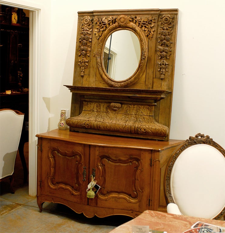 An unusual French 19th century carved wooden trumeau mirror from Normandy with large acanthus leaf base, shelf and oval mirror. Born in the Normandy region of France, this Northern French trumeau mirror features an unusual design. While the general