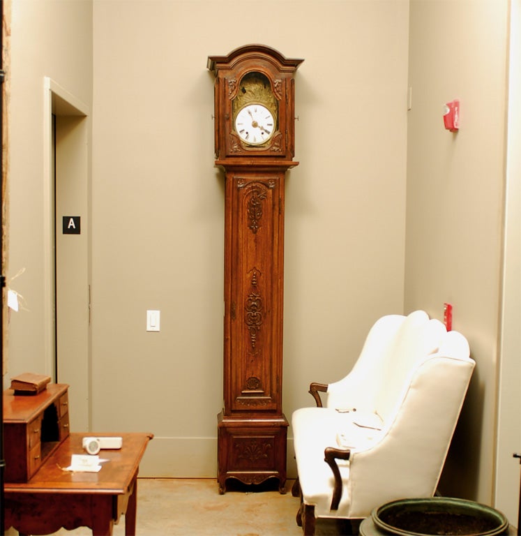 A French Napoléon III period carved walnut antique long case clock from the mid-19th century, with bonnet top, farming scene and scrolling motifs. Created in France at the beginning of Emperor Napoléon III's reign, this walnut grandfather clock