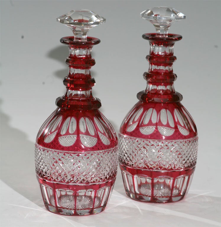 Hand blown crystal cranberry overlay cut to clear decanters with triple ring neck and matching stoppers.