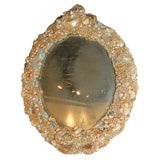 SMALL OVAL ANTIQUE MIRROR ENCRUSTED WITH SEA SHELLS.