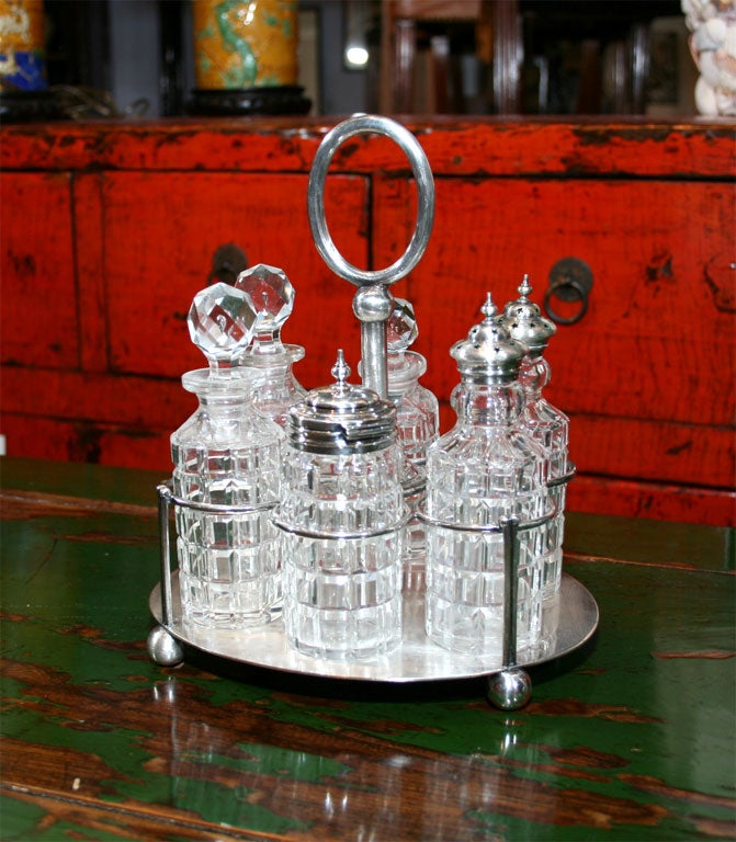 Six crystal bottles with tops this silverplate cruet set is a perfect additon to any table.   Signed W&H.