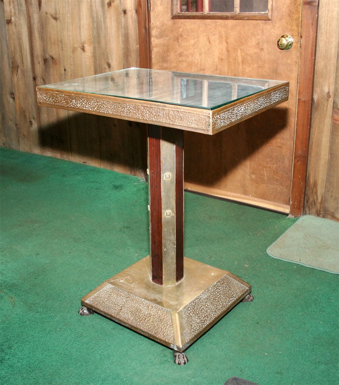 Wood side table covered in hammered brass with a glass top