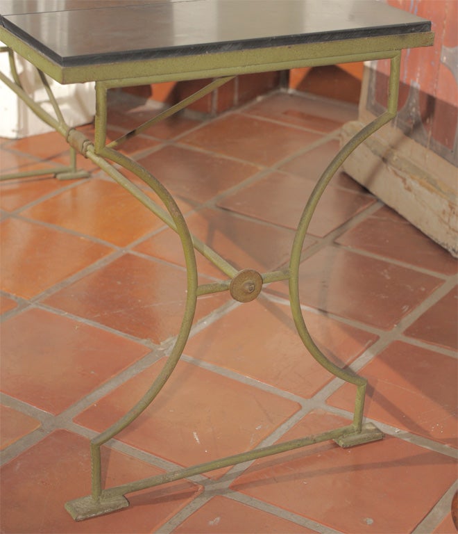 A green-patinated iron table base with black marble top in the Neoclassical style - circa 1940