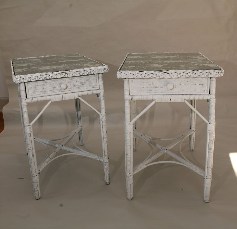 Matching pair of rectangular Bar Harbor wicker end tables in white paint, each having large single drawer.  Fabric covered wood tops under glass, bordered in traditional woven braiding.  Basket weave pattern to drawer fronts, side and back panels.