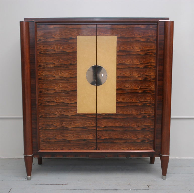 Art Deco cabinet. Rio Palissandre root with original center leather inlay.Chrome ornamental disk and sabots.