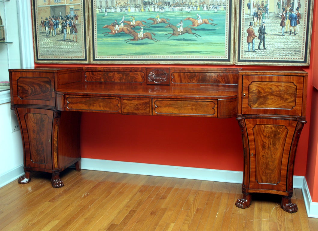 Fine quality large pedestal end Regency sideboard with a central carved shell,<br />
the pedestal ends with swiveling drawers fitted out  for wine, retaining a warm patina.