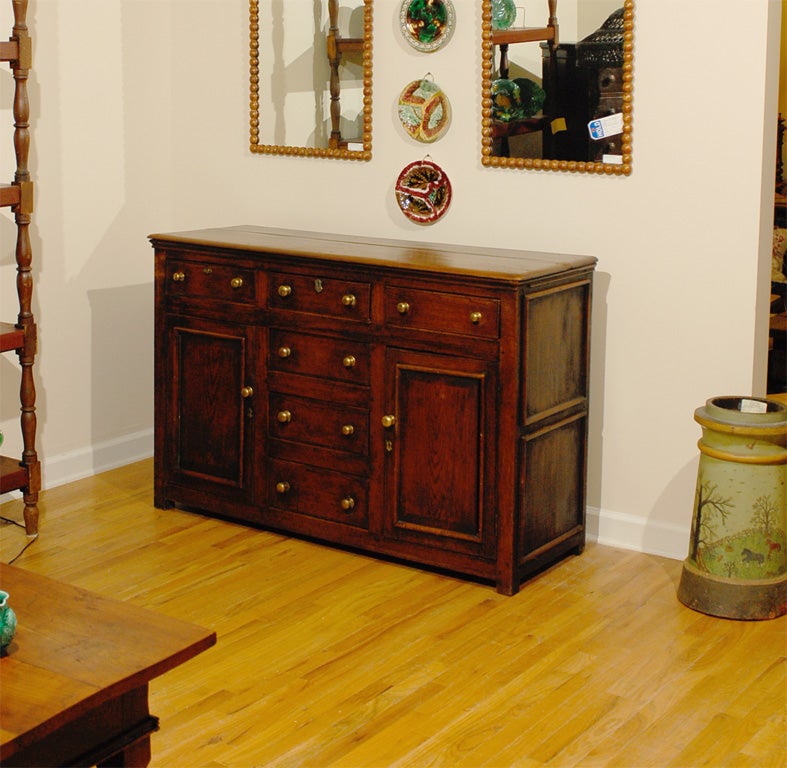 This is an English Dresser Base from the West Country c.1850-60.  This handsome dresser base has 6 drawers and 2 doors, excellent for storage.  The color and patina are warm and inviting.  The knobs are brass. <br />
<br />
Please visit our