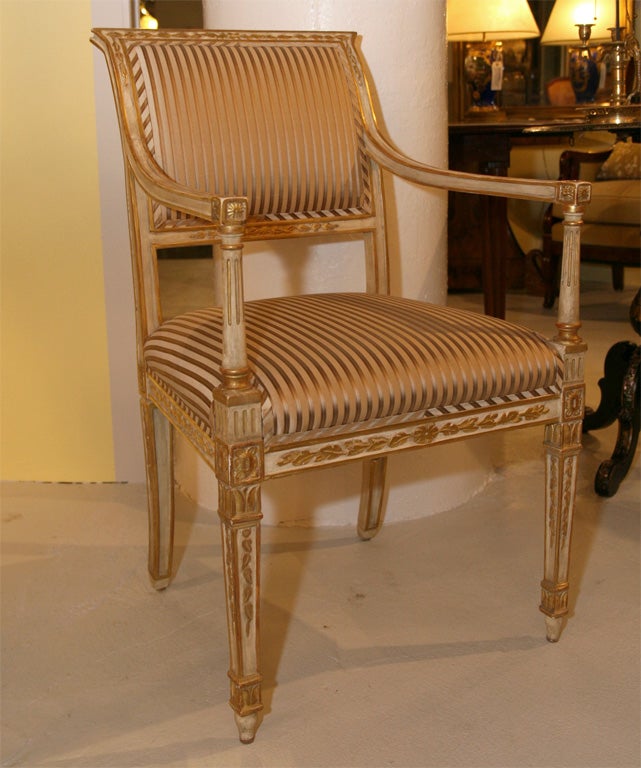 Exceptional pair of carved,gilded and painted Louis XVI style armchairs upholstered in heavy silk ticking. Visit QUOTIENTNYC.com to view our complete collection.