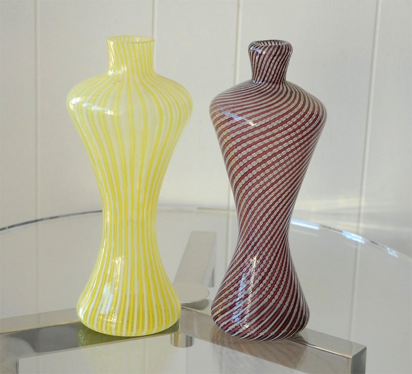 Two striped Murano glass vases. Yellow/white vase has vertical stripes while the purple/white vase has swirled diagonal stripes. Yellow vase as on old sticker label (made by Guildcraft Italy Genuine Murano Glass). Sold separately. Price is per vase.