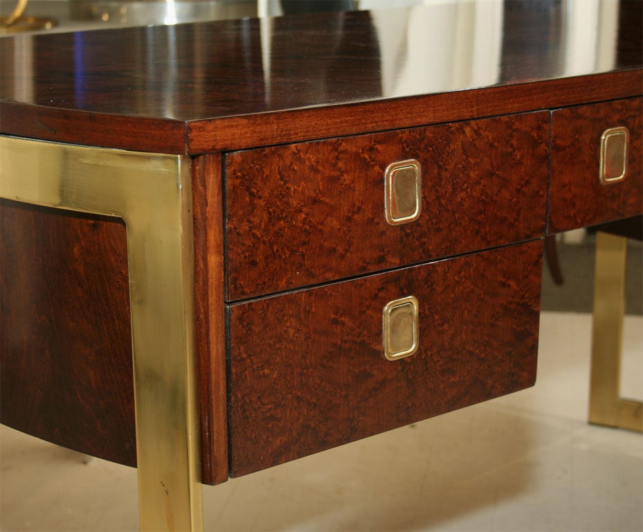 Burl wood desk with brass supports and handles.