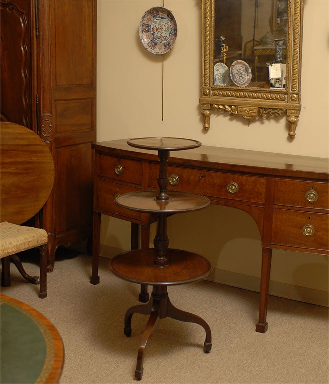An elegant and well-preserved Mahogany Dumbwaiter, with three tiers of serving space, and down-swept legs. Dating from the early George III period, and English in Origin. 

The three tiers all with moulded edges and richly-coloured mahogany, and the