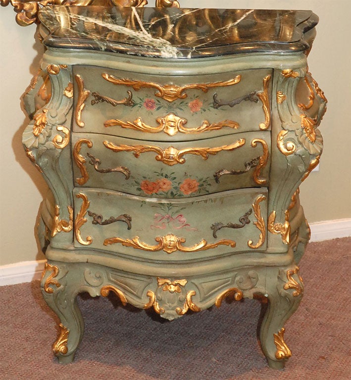 This petite pair of French 3-Drawer bombay chests are painted in a soft shade of green that has developed a nice patina.   These chests have roses and bows painted finely on the drawers.  Fabulous carved accents of gilt bring the tables to life. 