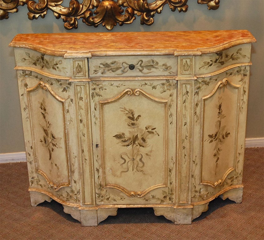 Petite venetian painted commode with faux painted top C. 1930.  This piece would fit perfectly in a powder room or small entry.  There is one center drawer and cabinet space underneath for storage.  The colors are gorgeous subtle colors of gold,