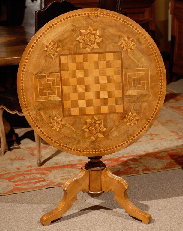 An intricate pattern of inlaid walnut and satinwood give this game table individuality and style.  The center portion is a checkerboard which is surrounded by a pattern of eight sided stars and bordered by a band of satinwood diamond shapes in