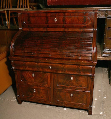 Fine mahogany roll top secretary, mid 19th century, with two pull-out desk features, one upper and one lower with compartmentalized drawers.  Original  bone escutcheons.