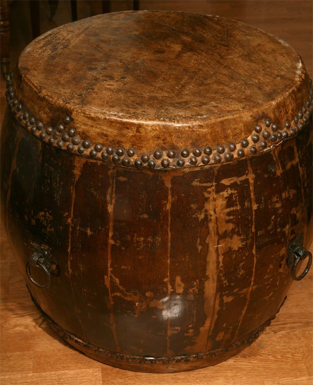 Large Chinese temple drum with parchment top and bottom, decorative nail head pattern, and four metal ring handles.