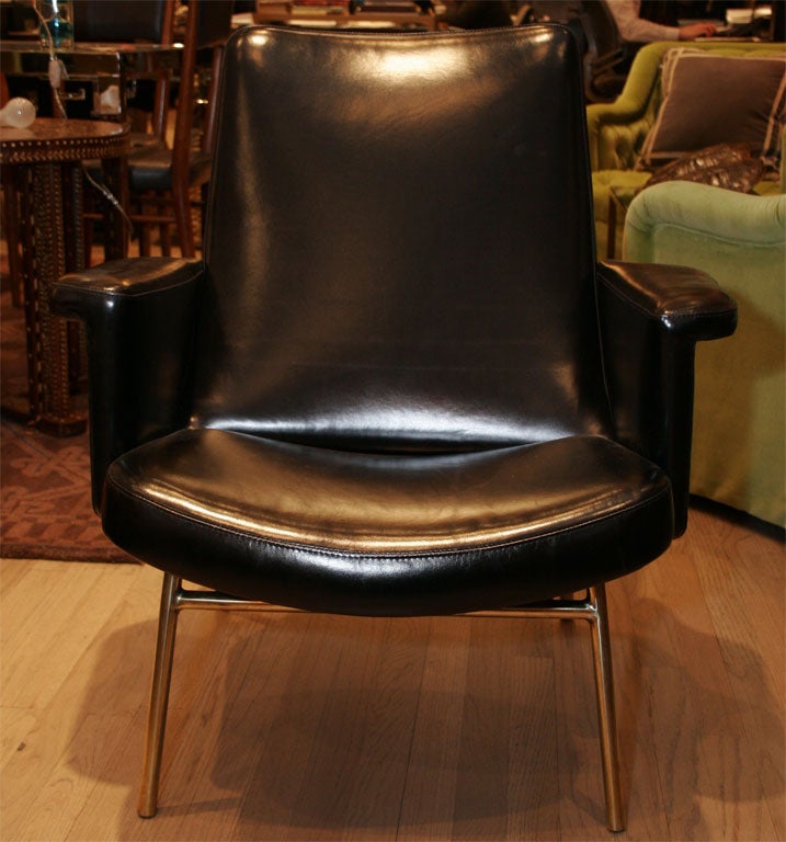 Very elegant pait of Pierre Guariche armchairs upholstered in black leather.

They are on a brass base and have very nice details.