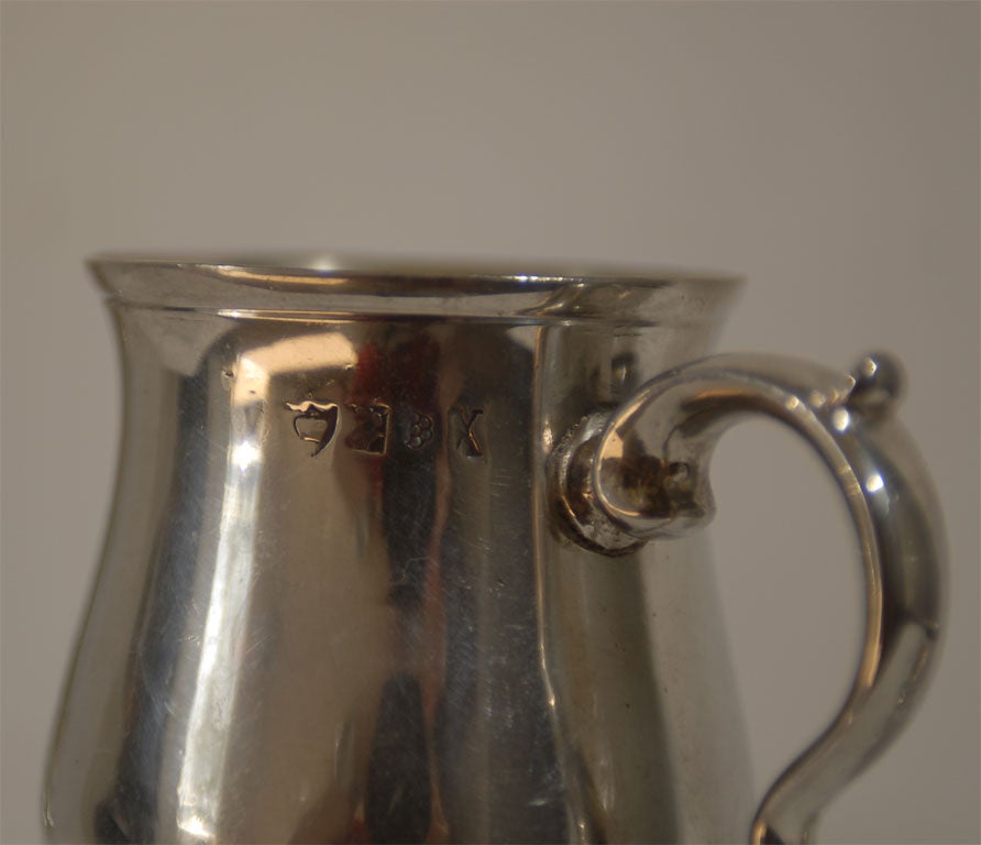 A set of three 18th century silver tankards with maker's stamps.  Though they appear different sizes in the main photo, they are actually a set and the photo is distorted based on the way in which they were positioned.  The handles are beautifully