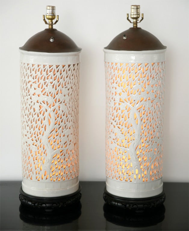 Large white porcelain cylinders, hand carved with a design of gridwork and bamboo are illuminated internally, forming large lamp bases. Excellent quality and design. Japanese, early 1950s.