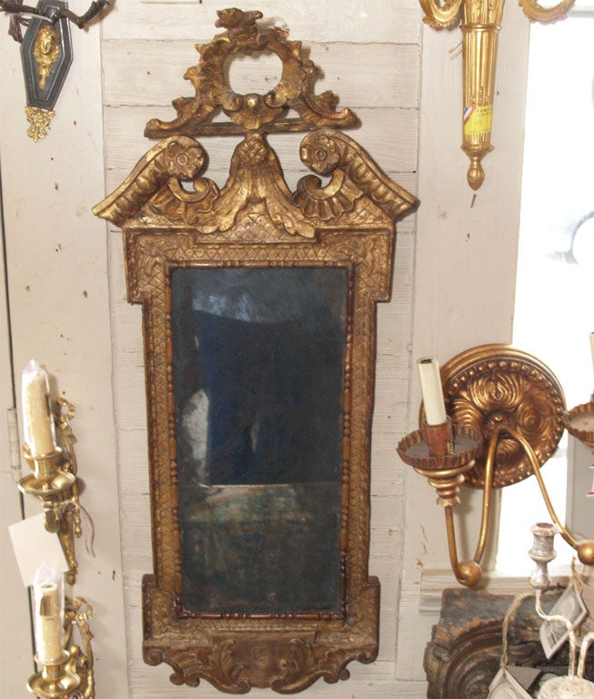 Antique glass plate in a carved giltwood frame with an open crest at the top.
