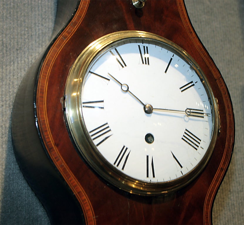 A very fine mahogany clock barometer, with tulipwood, boxwood and ebony inlay, having a swan neck pediment with a brass finial.