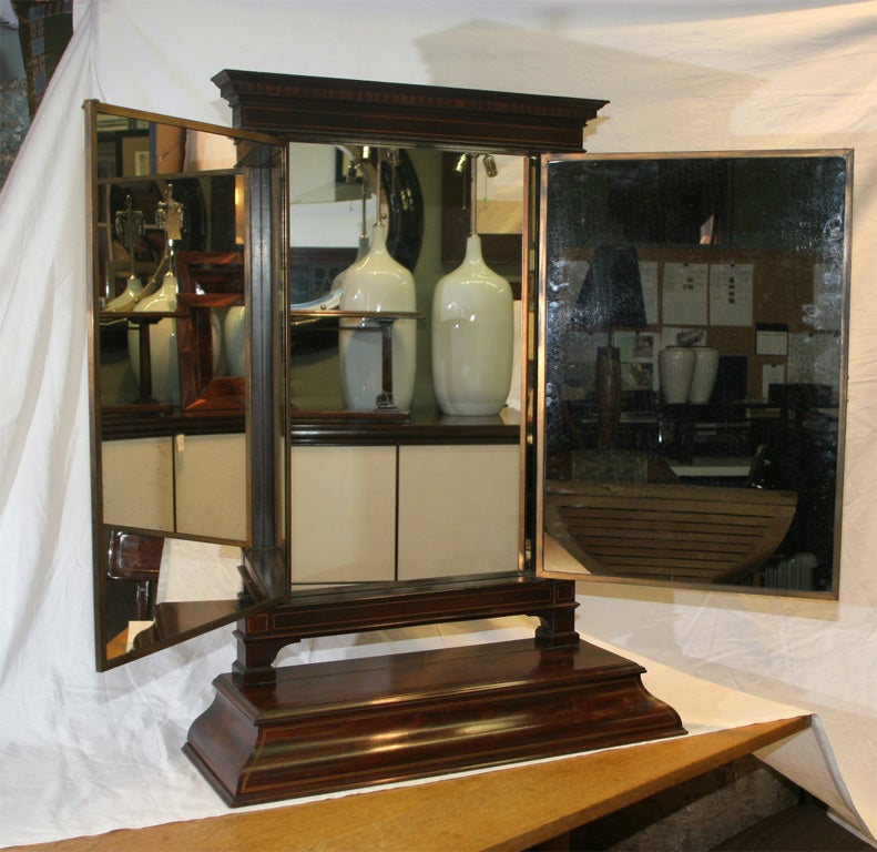 Mahogany three fold table top mirror.  Base contains a storage compartment.  Fully restored with antiqued glass.