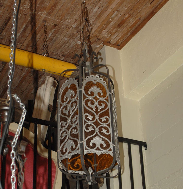 A extremely large European inspired Art Deco wrought iron and cast aluminum lantern style light fixture with inset textured amber color plexiglass or plastic type panels. 
Early 20th century, American.
Recently re-wired and ready to install. 
The